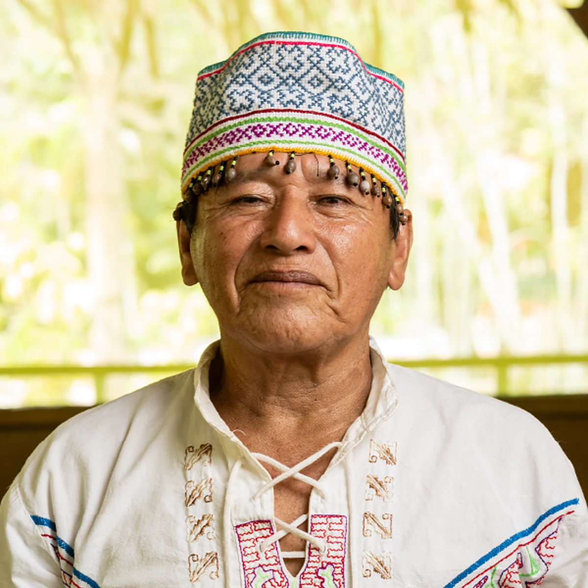 Maestro Miguel Muñoz in a white embroidered cushma and a beaded Shipibo hat